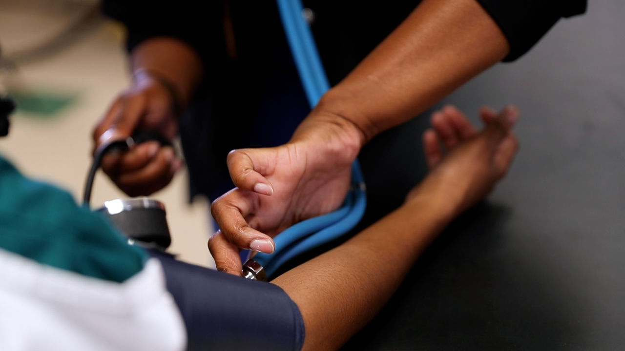 Healthcare worker checks blood pressure with stethoscope
