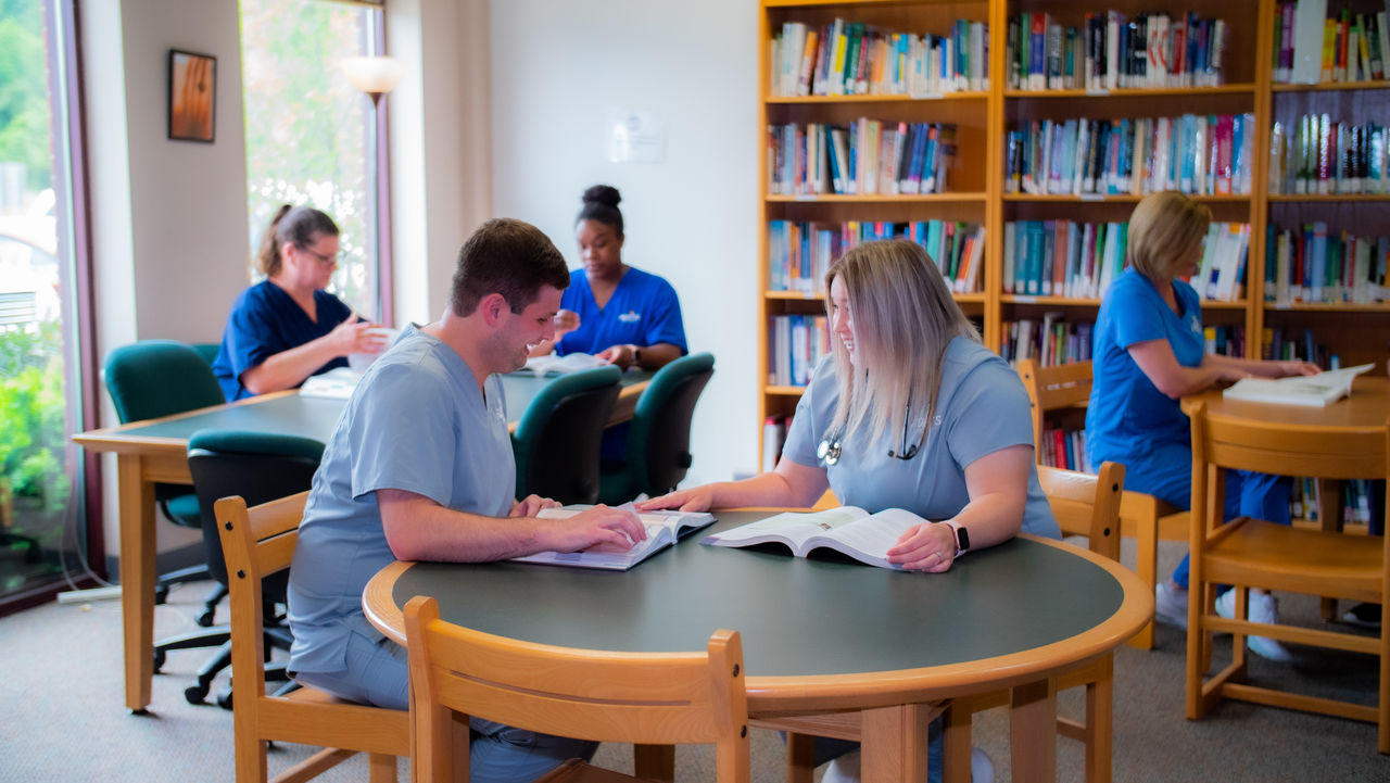 Medical students studying together in library setting