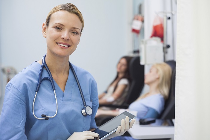 Nurse using a tablet computer in hospital ward