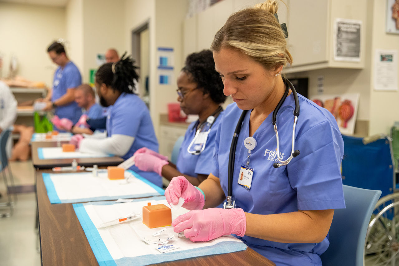 Nursing students practice medical procedures in classroom