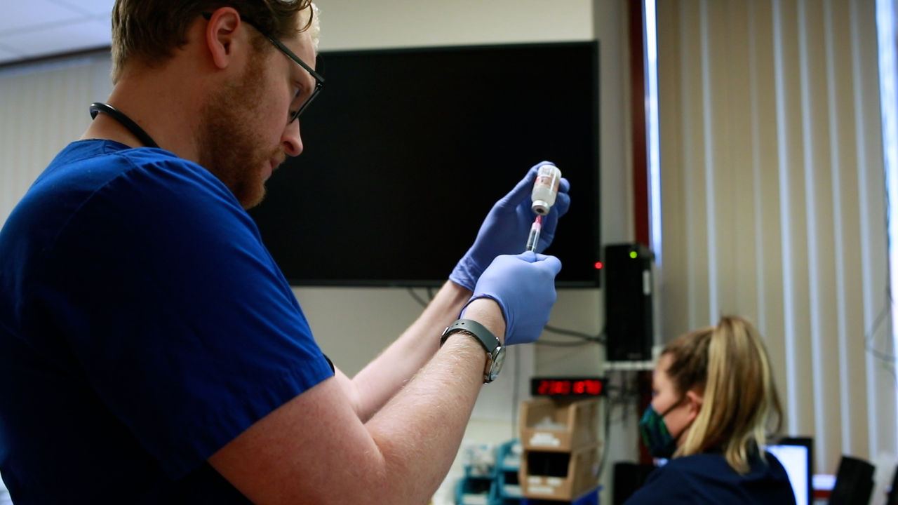 Healthcare worker prepares syringe in clinical setting