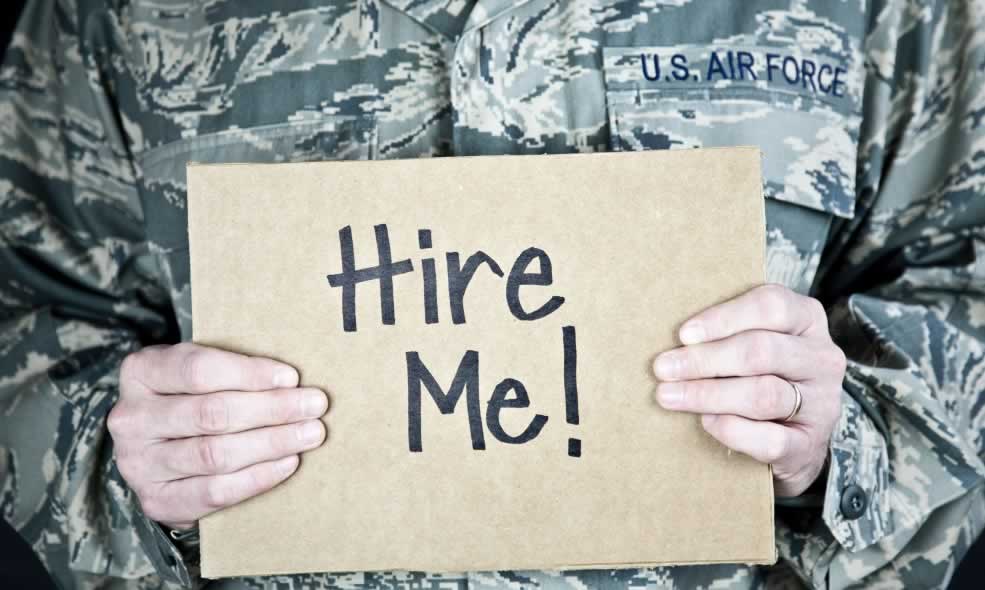 US Air Force member holding 'Hire Me' sign