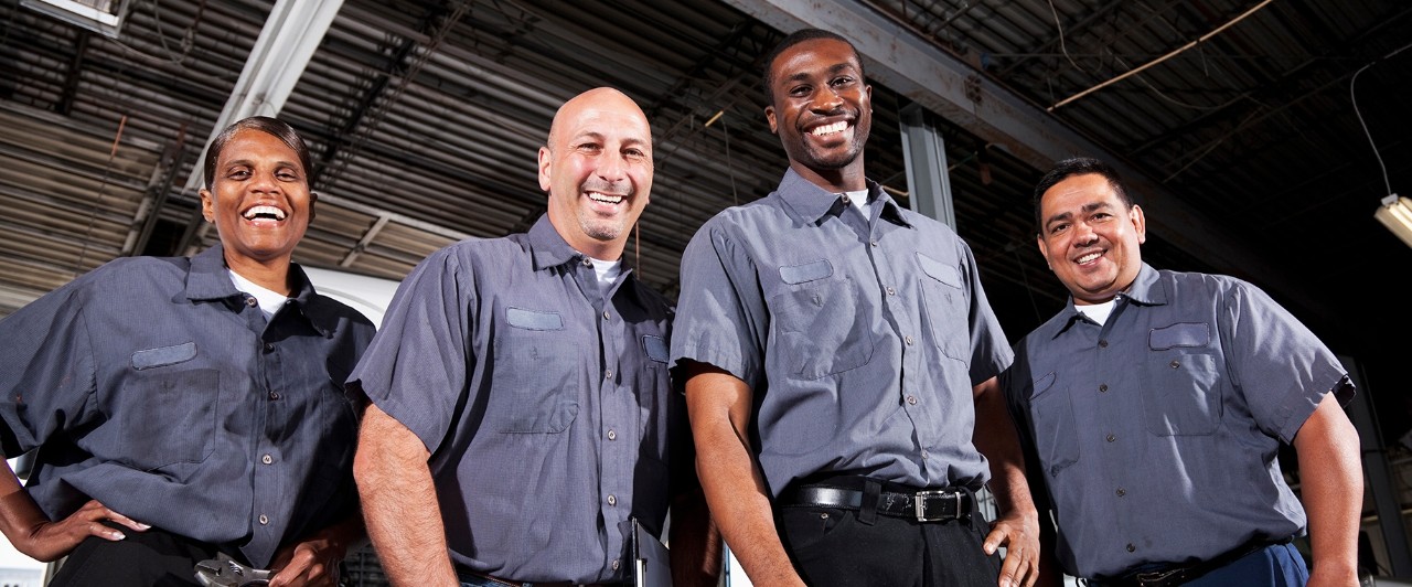 Multi-ehnic workers in service garage at trucking company.