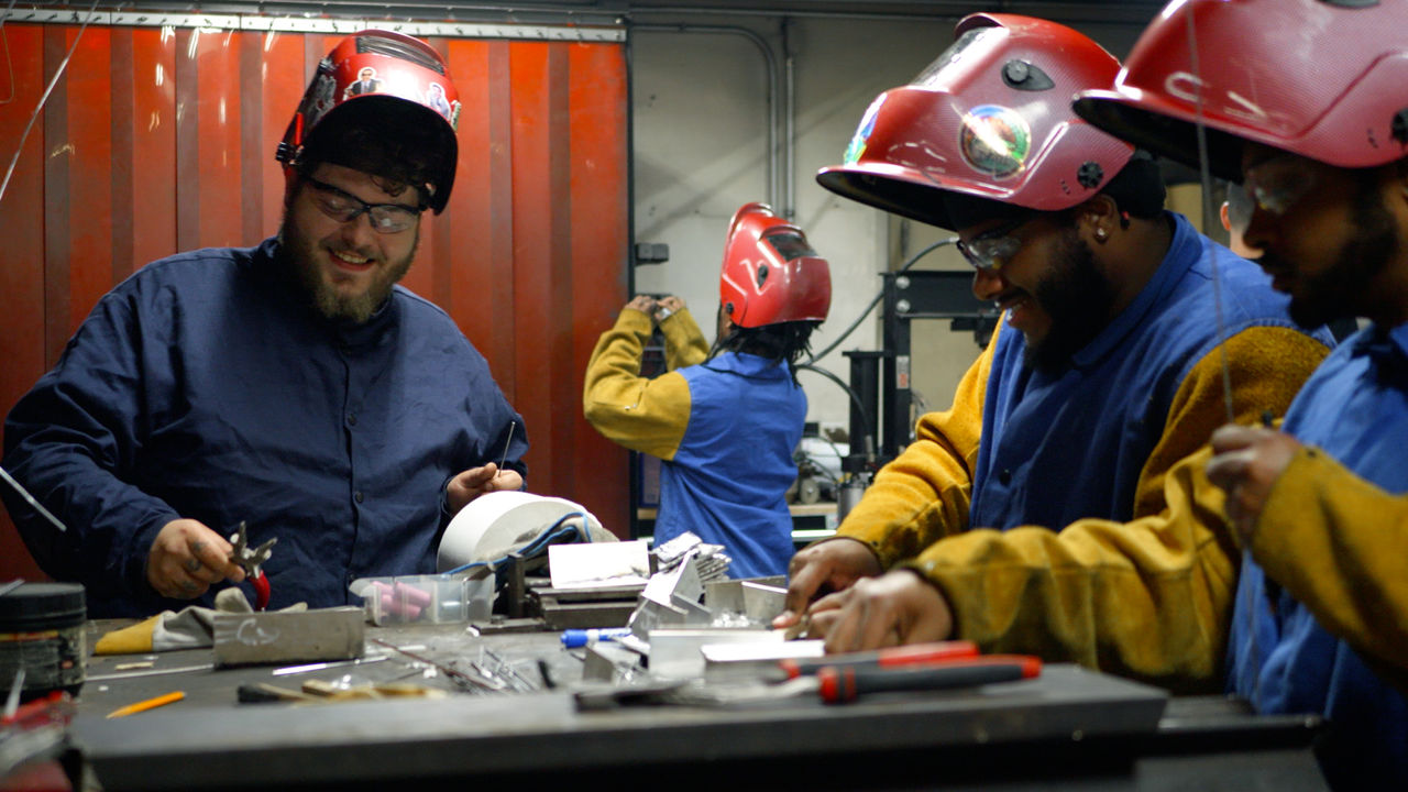 Group of welders working in industrial workshop