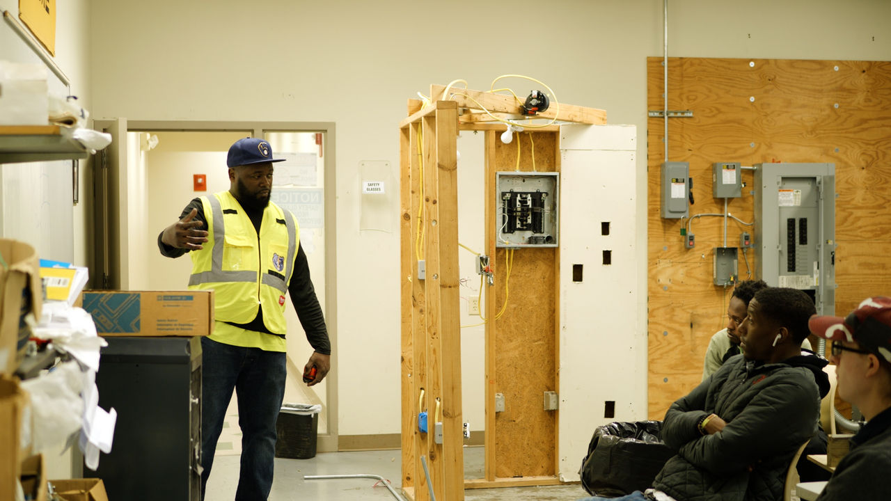 Instructor teaching electrical wiring in classroom workshop